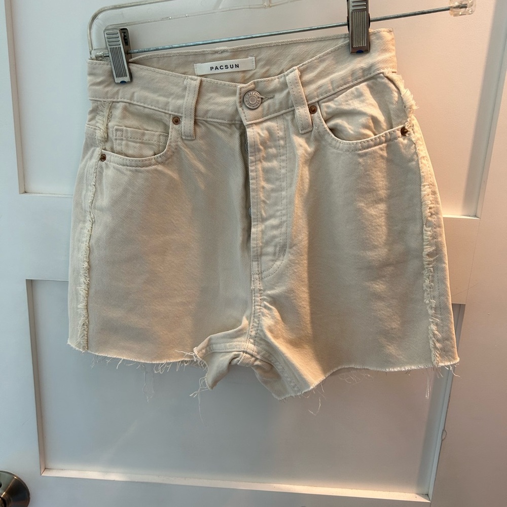 Cream cotton shorts with raw seams and hems.